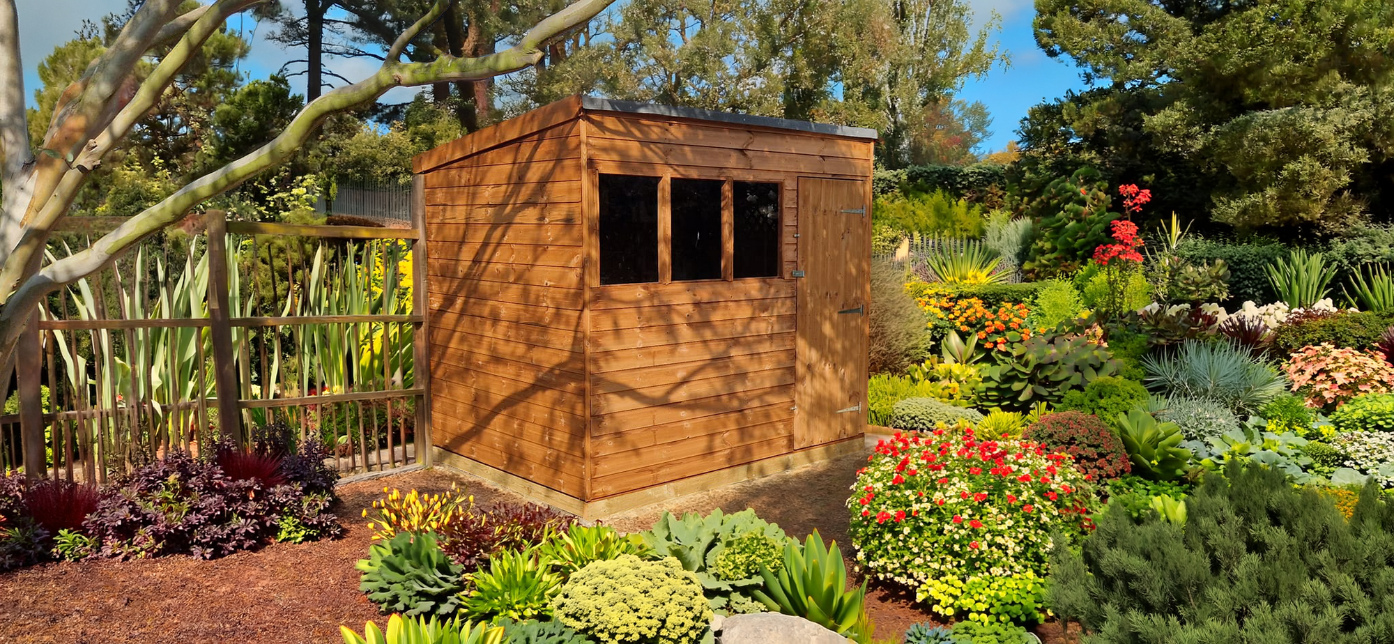 Shiplap pent shed installed in a garden setting surrounded by plants and flowers