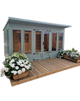 Welford summer house with glazed double doors and opening side windows on wooden decking by IN Sheds